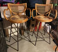 Front view of both wicker swivel stools showing metal bases and woven seats