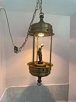 Full view of hanging oil rain lamp showing chain, cylindrical housing and lower reservoir