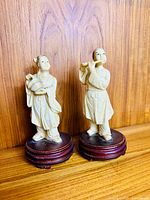 Front view of both resin Chinese figures on wood bases