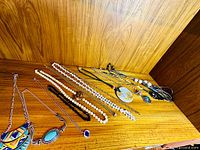 Overall view of all necklaces arranged on wood surface
