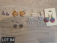 All five pairs of earrings laid out on wood surface