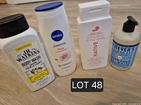 Front view of four unopened personal care bottles: J.R. Watkins Lemon body wash, Nivea Rose body wash, Native Candy Cane body wash, Mrs. Meyer’s Clean Day hand soap