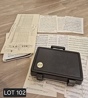 Closed Bundy case on top of sheet music and fingering chart