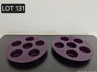 Two purple round silicone muffin trays on a table