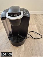 Front view of black Keurig coffee maker showing reservoir and power cord