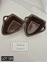 Top view of two brown glazed Maxwell Pottery boat dip pots with card identifying item