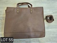 Front view of brown faux leather tote bag and rolled strap