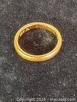 Gold wedding band on black background