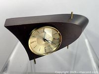 Full side view showing boomerang wood case, brass bezel and feet