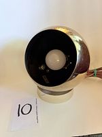 Front view of gold-tone eyeball lamp showing bulb and interior