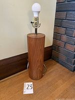 Front view of teak cylinder table lamp with bulb