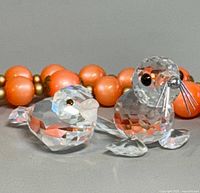 Front view of both crystal figurines: baby seal and bird