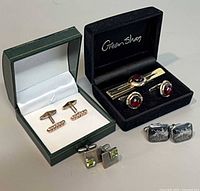 Group view of tie bar and four pairs of cufflinks in boxes