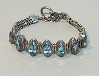 Front view of sterling silver bracelet showing seven marquise blue gemstones and toggle clasp