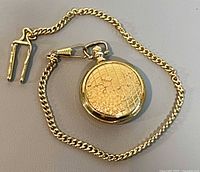Closed pocket watch with attached chain and clip