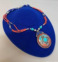 Full necklace on display form showing bead strands and pendant