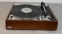 Front view of Noresco Dual 1229 turntable showing wood plinth, platter, and controls