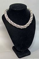 Necklace displayed on black bust form