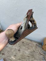 Side view of Stanley No.3 bench plane showing cast-iron body, wood knob, wood tote, lever cap, visible rust