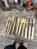 Top view of 10 hickory hammer handles laid out on wooden surface