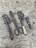 Group of four antique tools laid out on wood surface