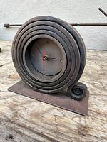 Front view of forged steel spiral clock on base