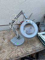 Full view of magnifying lamp showing arm, head, and base