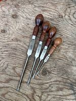 Four rosewood handle screwdrivers laid on wood surface