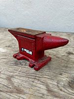 Left-front view of red Prairie Tool Co. bench anvil showing horn, face and maker’s badge