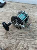 Side view of vintage baitcasting reel with green line