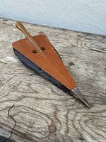 Overall view of triangular wooden bellows with leather sides and metal nozzle