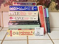 Stacked view of assorted antique reference books showing spines