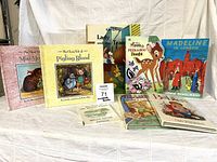 Group shot of all eight children’s books standing and lying on cloth backdrop