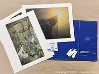 Folio partially open with two visible prints: NASA telescope assembly interior view and sunrise exhaust plume illustration