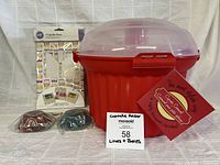 Front view of red cupcake carrier with lid, two bags liners, Wilton boxes