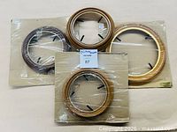 Top view of four round plate frames on cardboard backing, three in sealed plastic