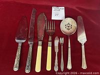 Full view of all eight serving utensils on red cloth
