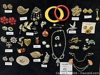 Overall view of 45 costume jewellery pieces on black background