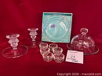Group shot showing all glass items—candlesticks, open salts, serving dish in box, dome and plate