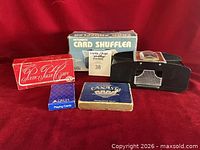 Group view of card shuffler, poker chips box, playing card decks, shuffler box