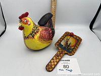 Hen and clapper noisemaker overview with ruler for scale