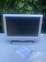 Front of Venturer 19-inch LCD TV on stand with printed manual