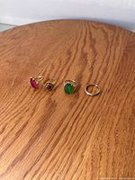 All four rings laid out on wood surface