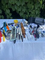 All items spread on table, overview of approx 30 kitchen tools and pans