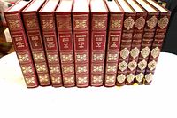 Front spines of 11 red gilt books displayed in a row