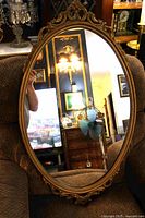 Full view of oval gilded mirror front
