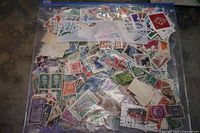 Front view of ziplock bag filled with assorted world stamps