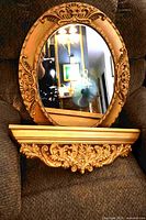 Mirror and shelf displayed together on chair