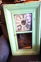 Front view of green-painted ogee clock