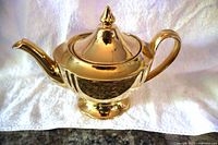 Front view of gold Royal Winton teapot showing pedestal foot and fluted body